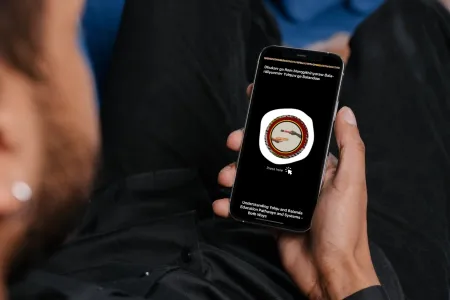 A young Indigenous Australian man looks at the Yolŋu Healthcare App on his phone
