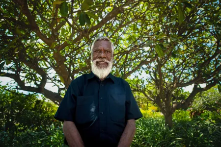 Elder stands in front of tree