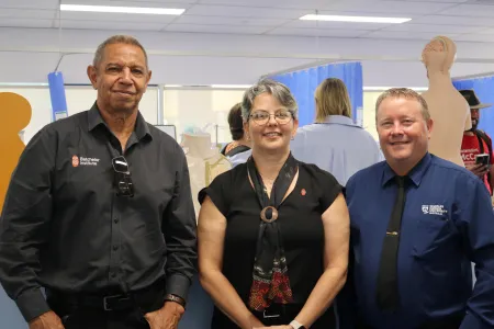 Three people pose in health facility