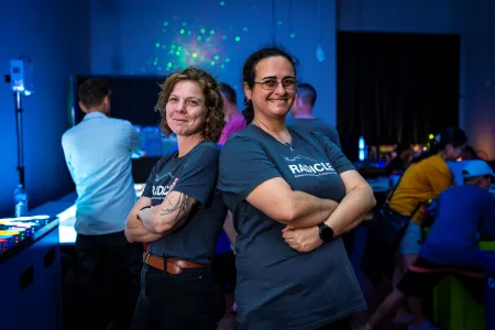 two people stand in dark room with glowing lights