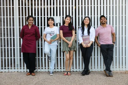 students leaning on wall outside