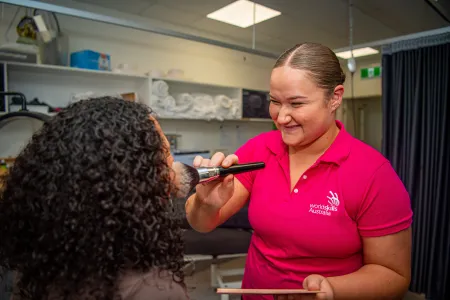 young student applies make up