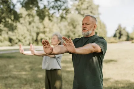 two people practicing tai chi outdoors