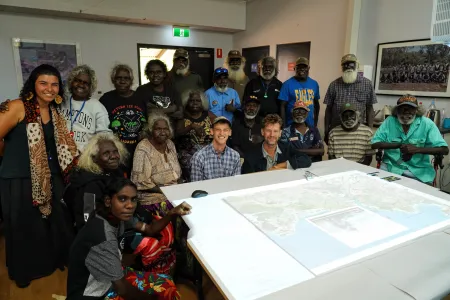 Sam Williams and Rohan Fisher (centre) with Maningrida Elders who supported the map. The model combines 3D technology and video to create an interactive map filled with traditional knowledge and stories. Credit: David Mason