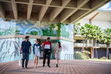 Four students walking around the Casuarina campus