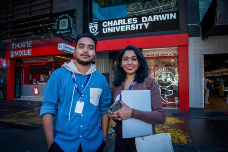 students stand in front of campus entrance