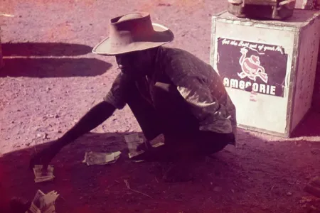 Indigenous Australian man squating and handling cash