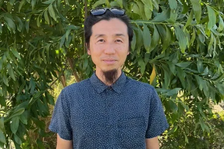 photo of yasunori hayashi standing infront of shrubery