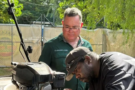 Lecturer with student fixing a lawn mower