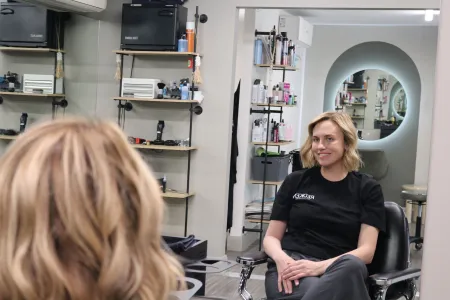 Esme sits in barbering chair