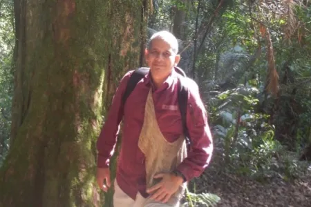Dr Mochamad Indrawan walking in the bush with trees in the background