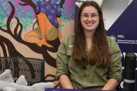 Young woman sitting in front of a desk looking at the camera