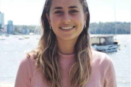 Headshot of Amy McAlpine with an urban river background