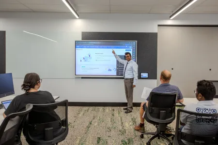 Trainer stands in front of screen pointing