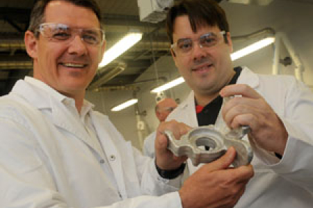Chief Minister Michael Gunner (left) and Steven Camilleri, inventor of the LightSPEE3D Printer. Steven holds an automotive part produced by the printer. 