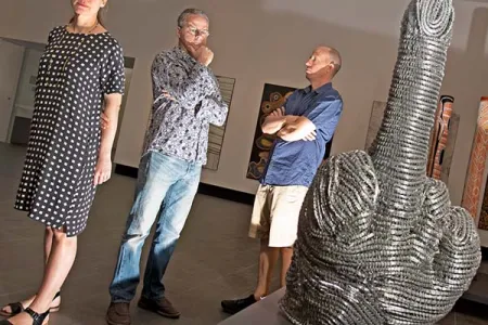 CDU Art Gallery Curator Kellie Joswig with Paul Johnstone and  Matt Ward from Salon Indigenous Arts Projects contemplating Indigenous artist Robert Wuldi’s response to being told by the art world to produce something more “traditional”