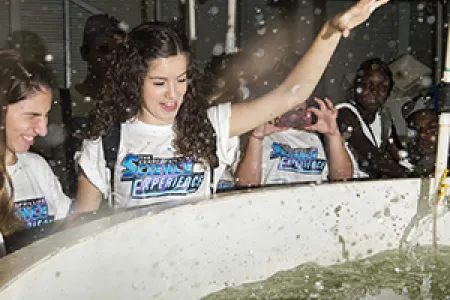 Secondary student Kathy Vazanellis feeds barramundi at the ConocoPhillips Science Experience
