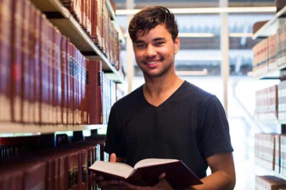Mark in the library holding a book