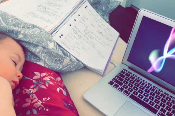 Loki sleeping next to Sharni's laptop and notebook