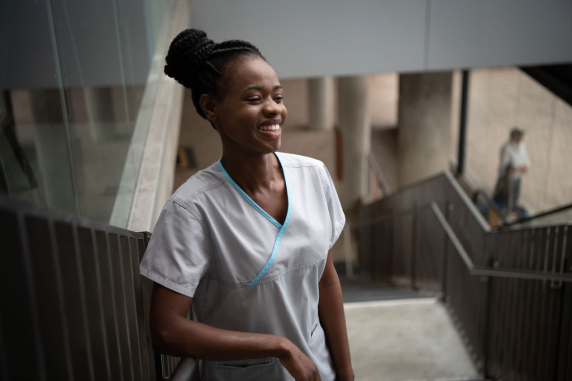 CDU nursing student Fifi Giraneza smiling, standing on a set of stairs