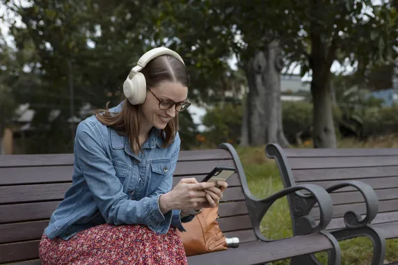 Student scrolling through phone listening to music