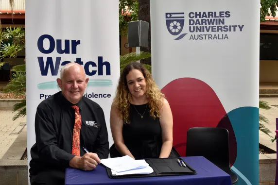 man and women pose in front of banners