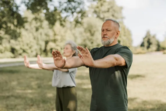 two people practicing tai chi outdoors