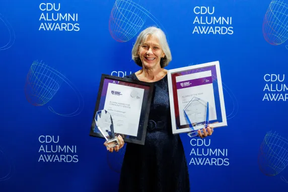 Esther stands with her two awards and certificates 