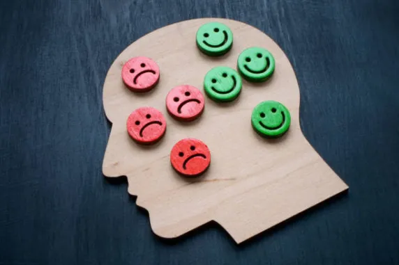 wooden head with sad and happy smileys