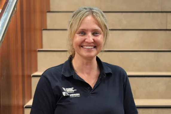 smiling staff anneka smiles and sit of steps in danala campus