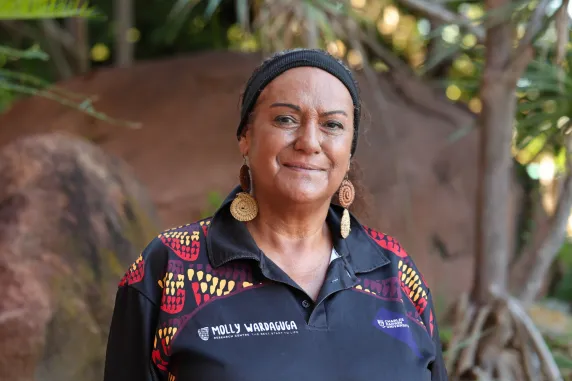 shirley spicer stands in front of ochre rocks at casuarina campus
