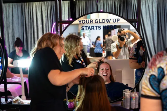 image fo a reflection of a woman getting her hair done in front of a mirror