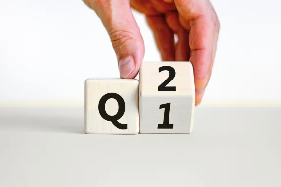 photo of two blocks with q and 1/2 written on it which a hnd grabbing one cube