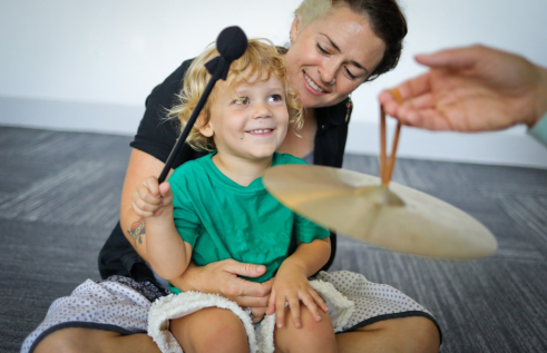 Child playing with cymbal