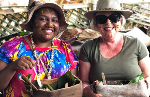 Two diverse women smiling and enjoying food