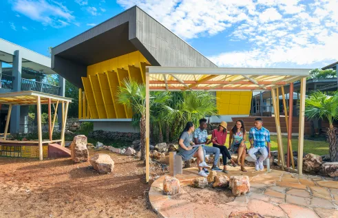 Students meeting in front of a campus building. Modern architecture.