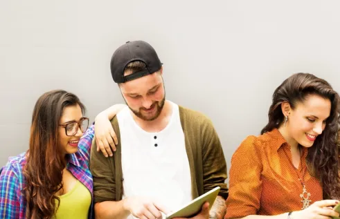 A group of people smiling and reading a pamphlet