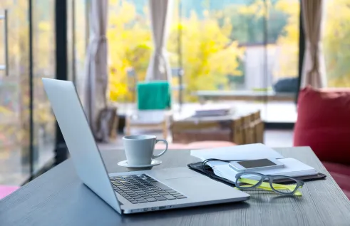 Study space with laptop, coffee, notepad and glasses