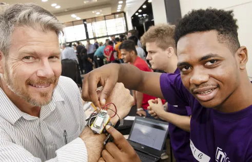 Student shows of robot strapped to the wrist of an onlooker