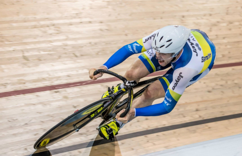 CDU student Jacob Schmid cycling on an indoor track