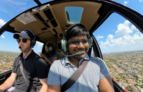 CDU student Sai Ram in a helicopter flying over the outback
