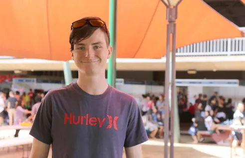 Nathaniel outside and smiling at the camera