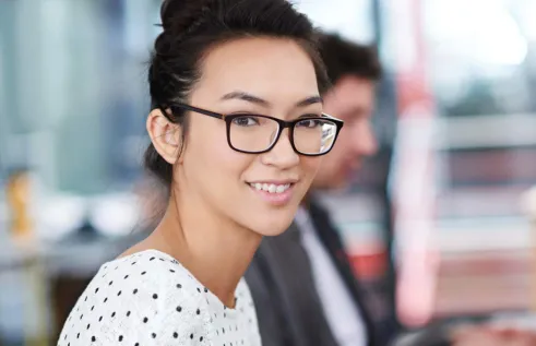Woman with glasses sitting in front of a computer