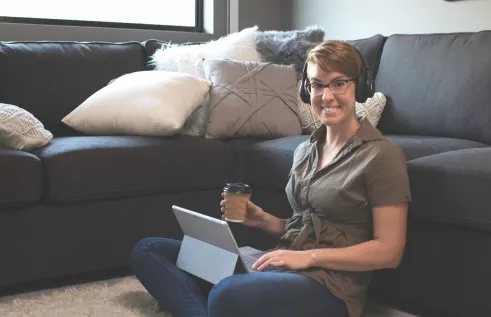 CDU student Ally working at home on her lounge floor