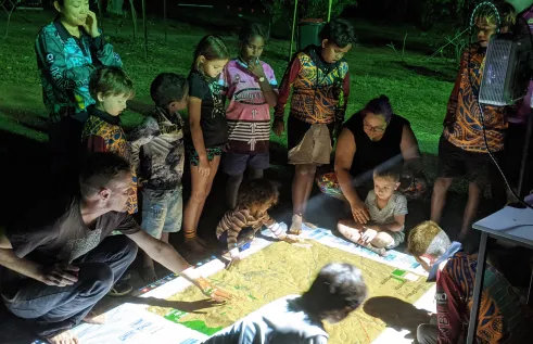 children and adults gather round 3D fire map