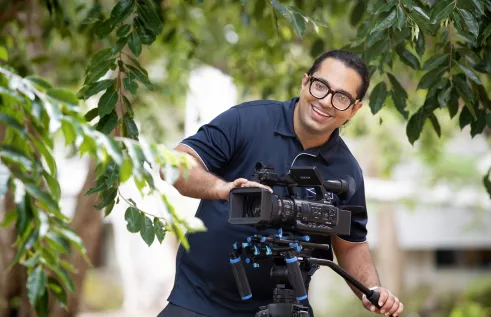 BP smiling in the garden holding a camera