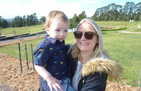 Sharni holding her son, Loki, in a field