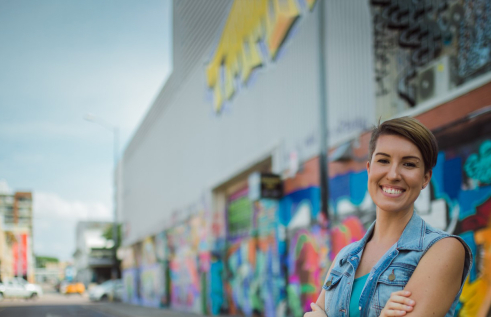 Smiling woman in front of graffiti