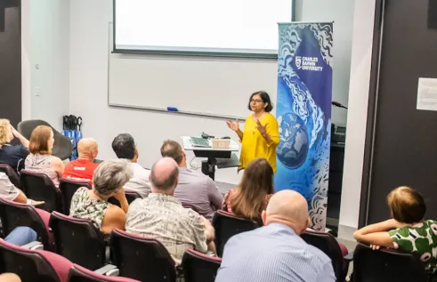 CDU lecturer presenting in fornt of a packed lecture theatre