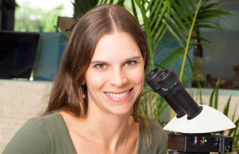 Dr Stefanie Oberprieler with a microscope